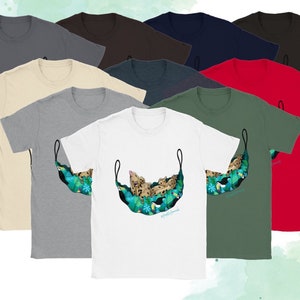 May include: A collection of short-sleeved t-shirts in various colors, including white, gray, and red. The shirts feature a graphic of a leopard relaxing in a hammock with tropical foliage and toucans. The text "#happylittlehammocks" is visible.