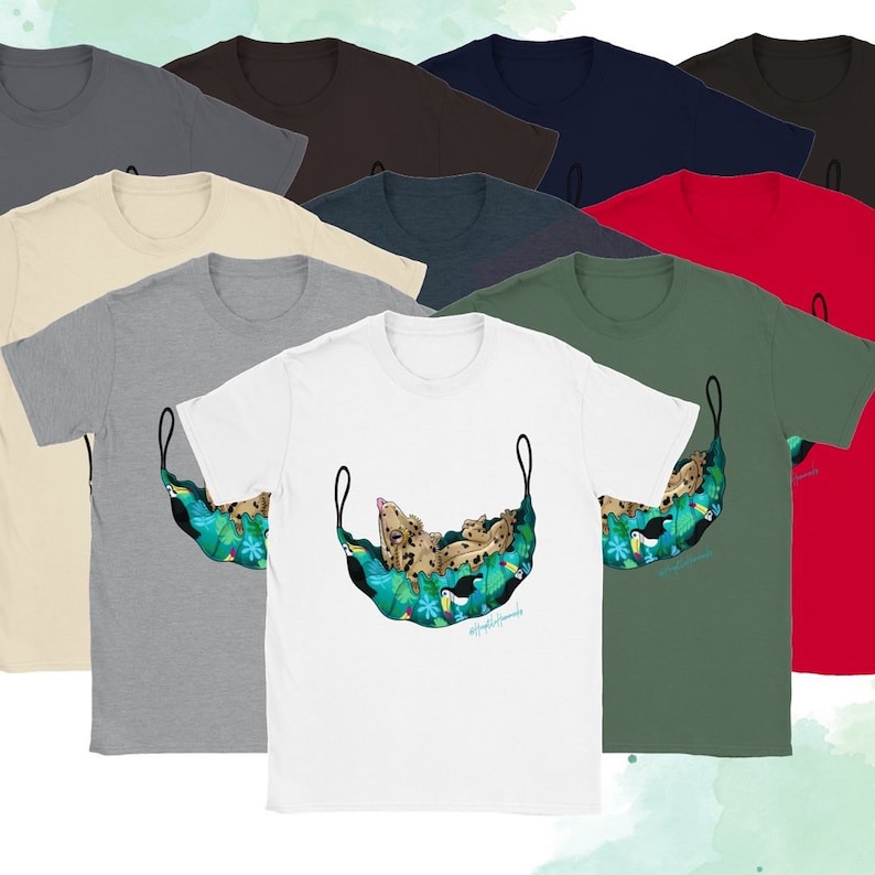 May include: A collection of short-sleeved t-shirts in various colors, including white, gray, and red. The shirts feature a graphic of a leopard relaxing in a hammock with tropical foliage and toucans. The text "#happylittlehammocks" is visible.