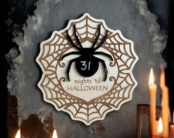 May include: A wooden countdown plaque with a black spider and web design. The plaque has a black circle with the number 31 written in white and the text "nights 'til HALLOWEEN".