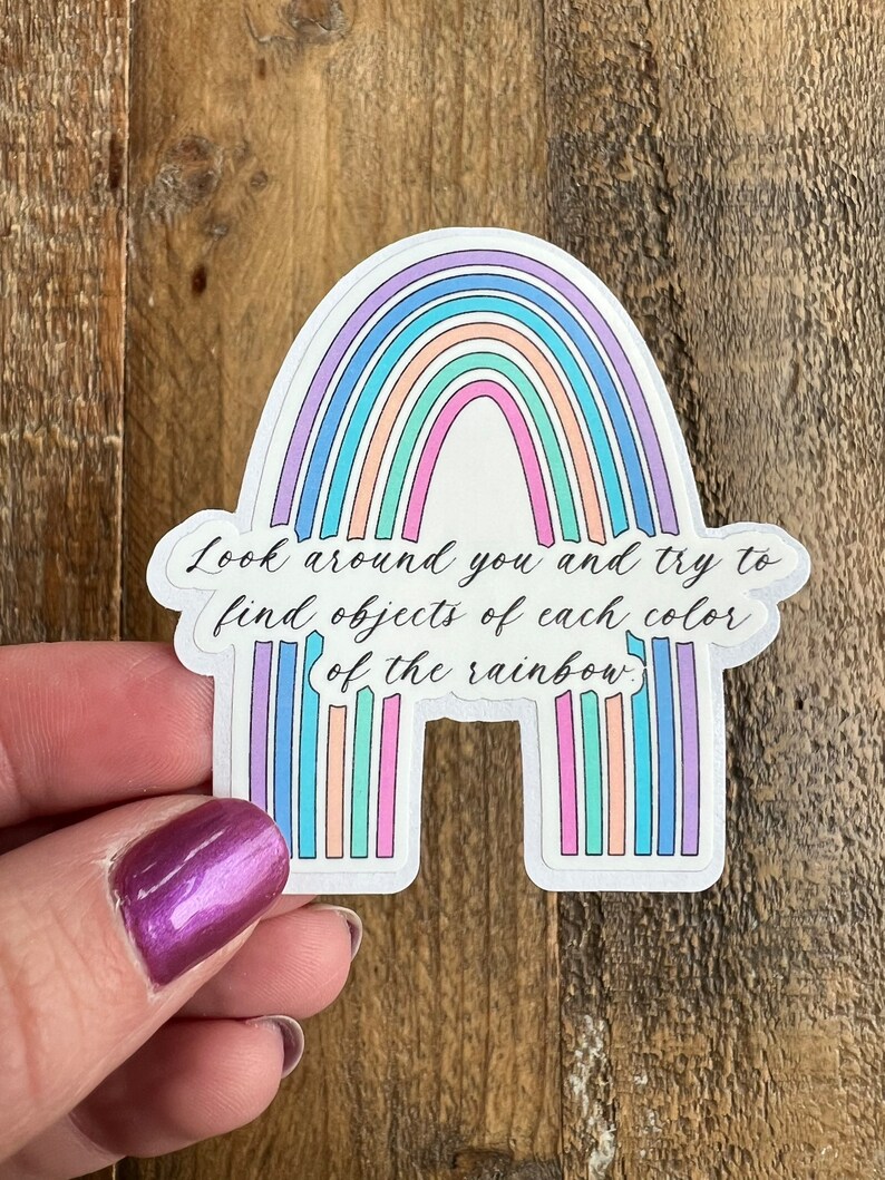 May include: A rainbow sticker with the text "Look around you and try to find objects of each color of the rainbow."