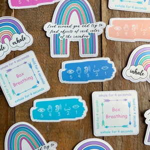 May include: A set of colorful rainbow stickers with the words "inhale" and "exhale" on them. The stickers also include instructions for box breathing, which is a breathing exercise that can help to calm and relax the mind and body.