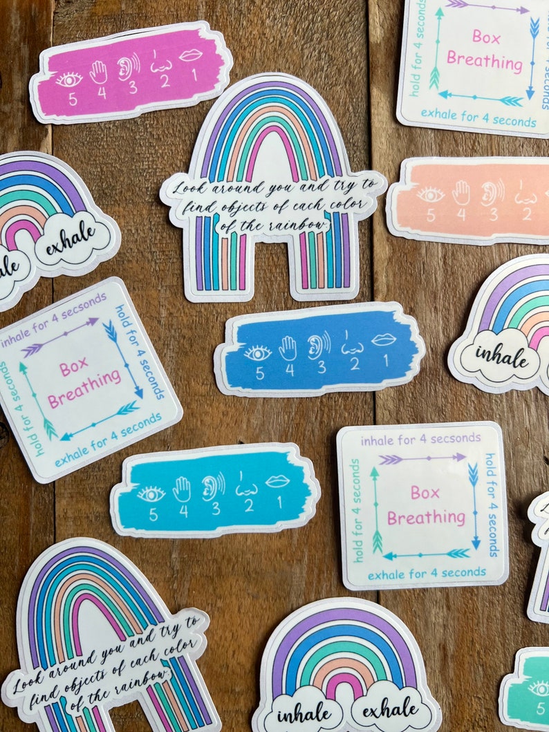May include: A set of colorful rainbow stickers with the words "inhale" and "exhale" on them. The stickers also include instructions for box breathing, which is a breathing exercise that can help to calm and relax the mind and body.