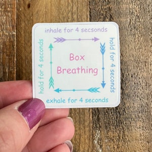 May include: A white sticker with a blue, pink, and green box breathing diagram. The diagram shows arrows with the text "inhale for 4 seconds", "hold for 4 seconds", "exhale for 4 seconds", and "hold for 4 seconds". The text "Box Breathing" is in the center of the box.