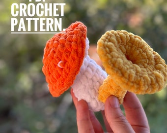 May include: Two crocheted mushrooms, one orange and white, the other yellow. The mushrooms are held in a hand. The image includes the text "PDF CROCHET PATTERN."