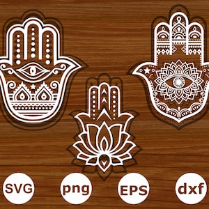 Peut inclure: Trois motifs de main de hamsa blancs avec des détails complexes. Le motif central présente une fleur de lotus. Les motifs sont sur un fond de bois brun.