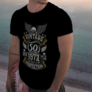 May include: Black t-shirt with a vintage design featuring a golden eagle, the text "Vintage", "Premium Quality", "50 Years", "1972", "Limited Edition", "One of a Kind", "Aged to Perfection", and stars.