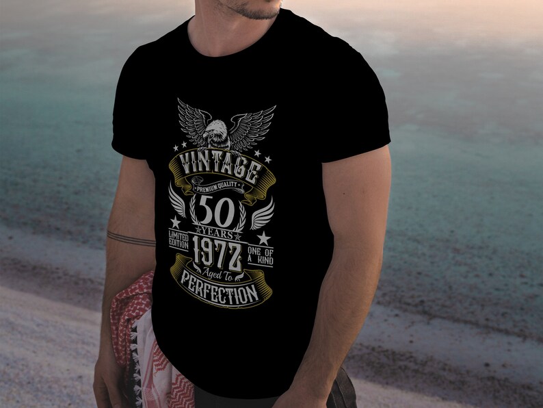 May include: Black t-shirt with a vintage design featuring a golden eagle, the text "Vintage", "Premium Quality", "50 Years", "1972", "Limited Edition", "One of a Kind", "Aged to Perfection", and stars.