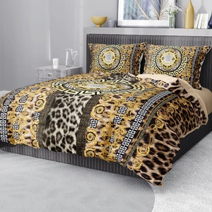 Op de afbeelding: Een beddengoedset met een gouden en bruin patroon met een luipaardprint. De set bevat een dekbedovertrek en twee kussenslopen.