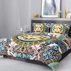 Op de afbeelding: Een beddengoedset met een wit, blauw en gouden patroon met een luipaardprint. De set bevat een dekbedovertrek en twee kussenslopen.