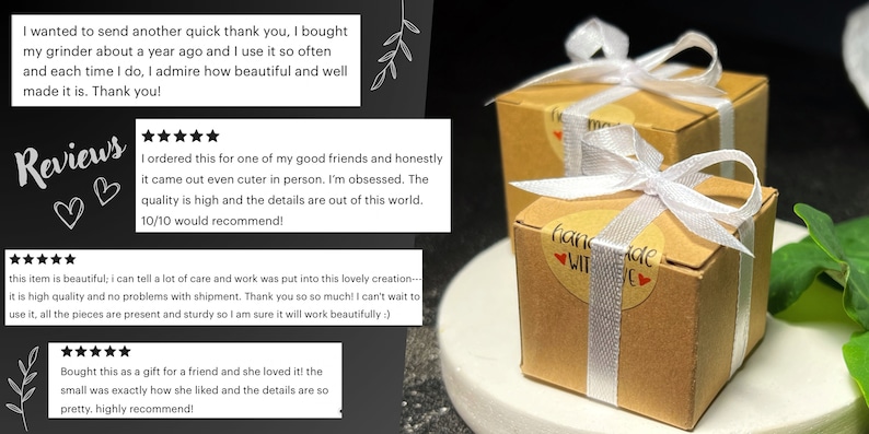 K&ouml;nnte beinhalten: Zwei kleine, quadratische Geschenkboxen aus braunem Karton, gebunden mit wei&szlig;em Band und einem Aufkleber "Handgefertigt mit Liebe". Die Boxen stehen auf einer wei&szlig;en Oberfl&auml;che mit gr&uuml;nen Bl&auml;ttern im Hintergrund.