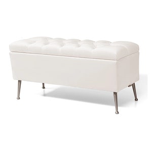 May include: White tufted storage bench with silver legs. The bench has a rectangular shape and a cushioned top.