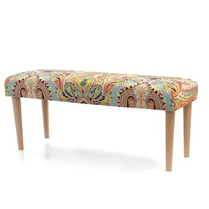 Puede incluir: Un banco largo y rectangular con un tejido estampado de paisley de colores que cubre el asiento y el respaldo. El banco tiene cuatro patas de madera.