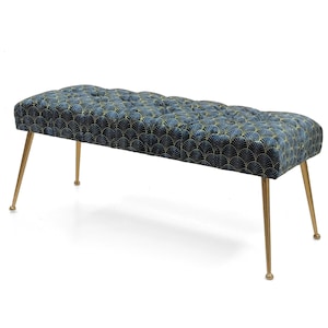 Puede incluir: Un banco de terciopelo azul con patas doradas y un patrón geométrico. El banco tiene un diseño capitoné y es perfecto para agregar un toque de elegancia a cualquier habitación.
