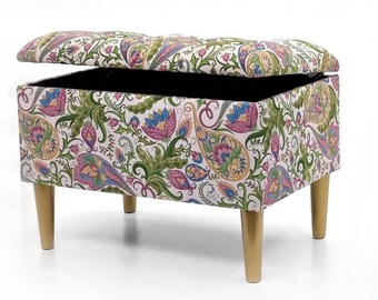Könnte beinhalten: Eine weiße Aufbewahrungstruhe mit einem Paisley-Musterbezug und goldenen Beinen. Die Oberseite ist geöffnet und zeigt ein schwarzes Innenleben.