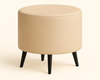 May include: A beige, round ottoman with a stitched top and three black, tapered legs. The ottoman is a neutral color and would complement various interior design styles. The legs are evenly spaced and provide a stable base.