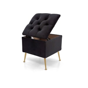 May include: A black storage ottoman with a tufted, hinged lid. The ottoman has a rectangular base and sits on four gold-colored, tapered legs. The lid is open, revealing the interior storage space.