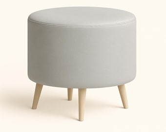 May include: A round, light gray ottoman with a stitched top and three wooden legs. The upholstered seat is a solid, neutral color. The legs are a light wood tone, providing a contrast to the gray fabric.