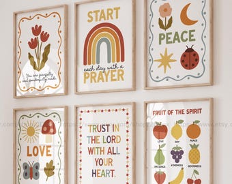 May include: A collection of six framed art prints with inspirational quotes and illustrations. The prints feature a rainbow, flowers, a sun, a moon, and various fruits. The color palette includes beige, red, yellow, and blue.