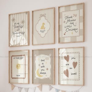 Può includere: Una collezione di stampe da parete incorniciate con citazioni e illustrazioni ispiratrici. Le opere d'arte presentano colori tenui, tra cui beige, crema e marrone, con testi come "Sei così amato" e "Dio è sempre con te".