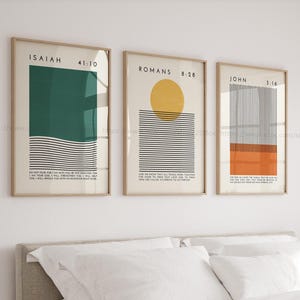 Peut inclure: Trois impressions d'art encadrées avec des designs minimalistes. Les impressions présentent des formes géométriques en vert, jaune et orange, avec des lignes noires et du texte d'Isaïe, Romains et Jean. Les cadres sont marron clair.