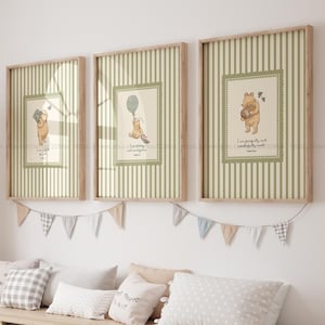 May include: Three framed prints with Winnie the Pooh illustrations. Each print has a light green and white striped background with a central image of Pooh Bear. The prints are in wooden frames and are hung above a bench with pillows and storage boxes.