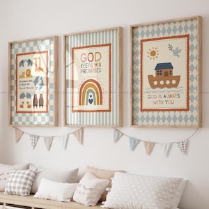 Könnte beinhalten: Drei gerahmte Wandbilder mit Arche-Noah-Motiven, einem Regenbogen, Tieren und den Texten God Keeps His Promises und God Is Always With You. Die Drucke haben hellblaue und cremefarbene Muster und hängen über einem Aufbewahrungsmöbel.
