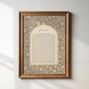 Può includere: Una stampa artistica da parete incorniciata con sfondo beige e un motivo floreale bianco ripetuto. Al centro, un pannello color crema ad arco contiene il testo del Salmo 91 stampato con un carattere scuro in stile macchina da scrivere.