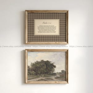 Peut inclure: Deux cadres muraux en bois clair. Le cadre supérieur contient un passe-partout beige à motif vichy marron avec le texte Psalm 1:1-3. Le cadre inférieur présente une peinture paysagère représentant des arbres et un chemin de terre.