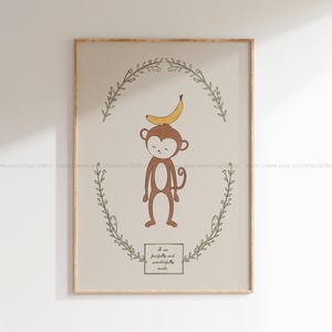 May include: A printable nursery art print featuring a cartoon monkey with a banana on its head. The monkey is brown and has a light brown face. The background is a light beige colour with a green leafy wreath around the monkey. The text "I am fearfully and wonderfully made" is written in a brown rectangle at the bottom of the print.