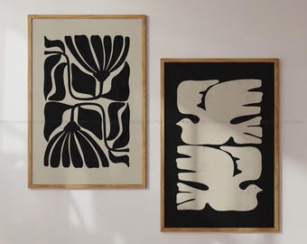Puede incluir: Dos impresiones enmarcadas con diseños abstractos en blanco y negro. La primera impresión presenta un diseño floral estilizado. La segunda impresión presenta un diseño de pájaro estilizado.