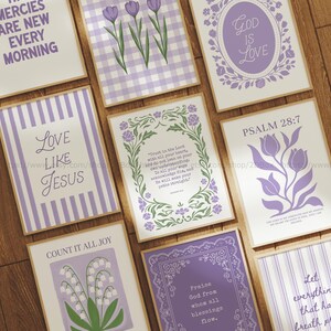 Puede incluir: Una colección de impresiones artísticas enmarcadas con citas inspiradoras y diseños florales en tonos morados y blancos. Las impresiones presentan textos como "Love Like Jesus" y "God is Love". Los marcos tienen un acabado de madera natural.