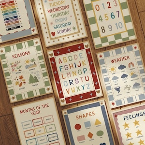 May include: A collection of educational posters with various themes, including the alphabet, numbers, seasons, weather, shapes, and feelings. Each poster features colorful designs and clear text, perfect for learning. The posters are arranged on a wooden surface.