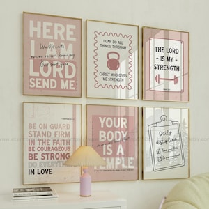 May include: Six framed wall art prints with inspirational quotes in pink and white. The prints feature phrases like "The Lord is my strength" and "Your body is a temple." The frames have a gold finish.