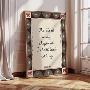May include: A framed print with the text "The Lord is my shepherd; I shall lack nothing. Psalm 23:1." The print has a gold frame and a decorative border with floral and geometric elements in brown, green, and blue.