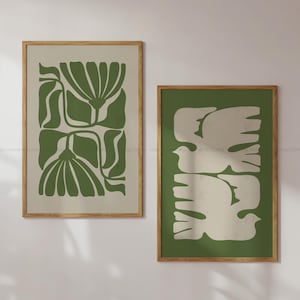 May include: Two framed prints with abstract designs. The print on the left features a green floral pattern. The print on the right features a green background with white stylized birds.