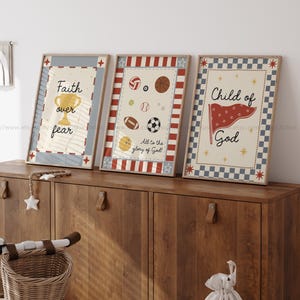 May include: Three framed prints with inspirational messages. The first print says "Faith over fear" with a gold trophy. The second print has sports balls and says "All to the glory of God". The third print says "Child of God" with a red flag.