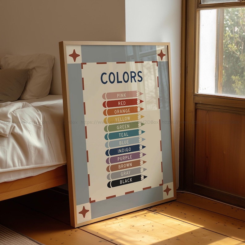 May include: A framed poster with the word "COLORS" in navy blue, listing various colors with corresponding colored pencils. The poster has a light beige background with a light blue border and decorative star-shaped accents in each corner. The poster is leaning against a wall.