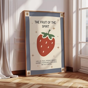 Könnte beinhalten: Ein gerahmter Kunstdruck mit einer stilisierten Erdbeer-Illustration. Der Druck hat einen beigen Hintergrund, einen blauen Rahmen und einen goldenen Rahmen. Der Text lautet "DIE FRUCHT DES GEISTES" und listet Tugenden wie Liebe, Freude und Güte auf. Dekorative Sterne umgeben das Bild.