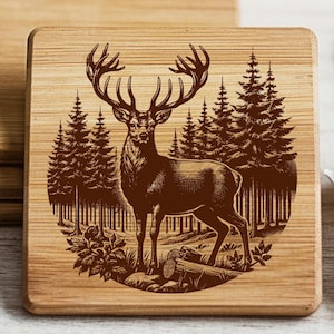 Può includere: Sottobicchieri quadrati in legno con un disegno inciso al laser di un cervo in una foresta. I sottobicchieri sono in legno chiaro e impilati. Il testo "Cutting Boards, Coasters & More" è in alto.