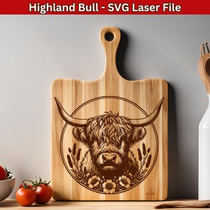 May include: A wooden cutting board with a laser-engraved design of a Highland bull's head with a floral wreath. The bull has long, shaggy hair and a brown nose.