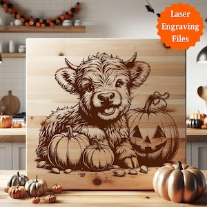 Pu&ograve; includere: Un cartello in legno con un disegno inciso al laser di una mucca delle Highlands e zucche. La mucca sorride e ci sono tre zucche, una con una faccia di lanterna. Il cartello ha il testo "Laser Engraving Files" in un cerchio arancione.
