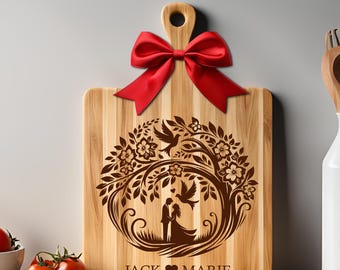 May include: A wooden cutting board with a laser-engraved design of a couple standing under a tree with birds. The design is surrounded by a circle of flowers and leaves. The text "JACK ♥ MARIE" is engraved below the design.