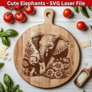 May include: A circular wooden chopping board with a handle, engraved with a design of two elephants and flowers. The text "Cute Elephants - SVG Laser File" is at the top. Tomatoes, basil, and cheese surround the board.