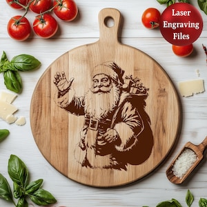 May include: A round wooden cutting board with a handle, featuring a laser-engraved image of Santa Claus waving. Santa is depicted with a long beard and a sack of gifts. The text "Laser Engraving Files" is in a red circle.