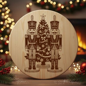 A wooden board with a circular design featuring two nutcracker men standing in front of a Christmas tree.