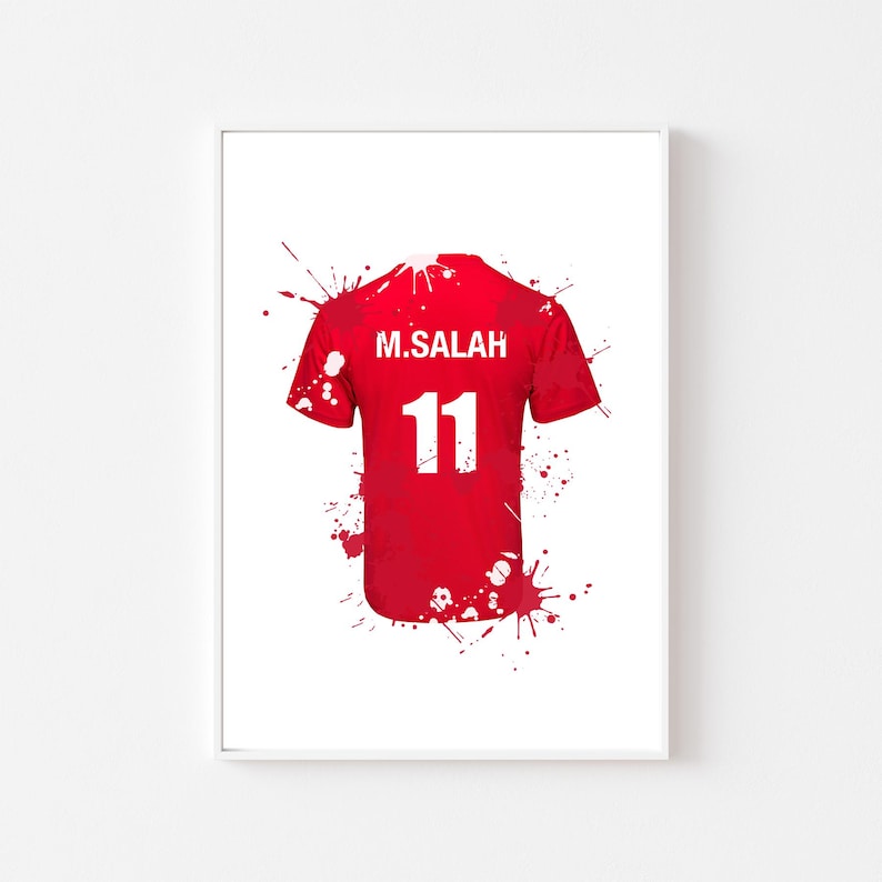 May include: Red soccer jersey with the name "M. SALAH" and the number "11" in white. The jersey is depicted with red paint splatter effects on a white background.