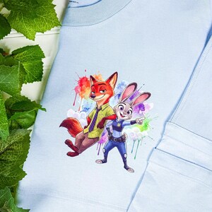 Puede incluir: Una taza de cer&aacute;mica blanca con un dise&ntilde;o floral colorido. La taza tiene un asa y un borde ancho. Las flores son en tonos de rosa, morado y amarillo. Para bebidas calientes.