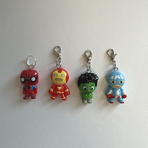 Könnte beinhalten: Vier Schlüsselanhänger mit Superhelden-Charakteren: Spider-Man, Iron Man, Hulk und Captain America. Jede Figur ist farbenfroh und an einem silberfarbenen Metallverschluss befestigt. Die Figuren sind etwa 5 cm groß.