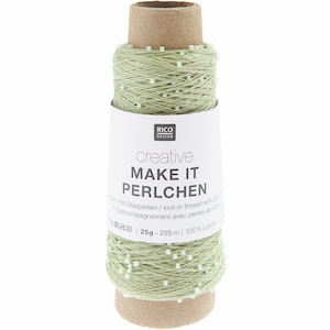 Könnte beinhalten: Eine Spule hellgrünes Garn mit kleinen weißen Perlen, beschriftet mit "MAKE IT PERLCHEN" von Rico Design. Das Etikett gibt an, dass das Garn 25g wiegt und 255m lang ist, aus 100% Lyocell besteht. Das Garn ist um eine Papprolle gewickelt.