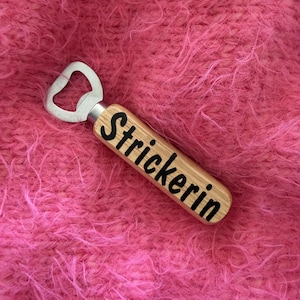 Könnte beinhalten: Handgefertigtes Holzschild mit dem Text "Willkommen" in einer verspielten Schriftart. Das Schild ist weiß lackiert mit einem Used-Look und zeigt ein florales Design in Rosa- und Grüntönen. Es ist etwa 30 cm breit.